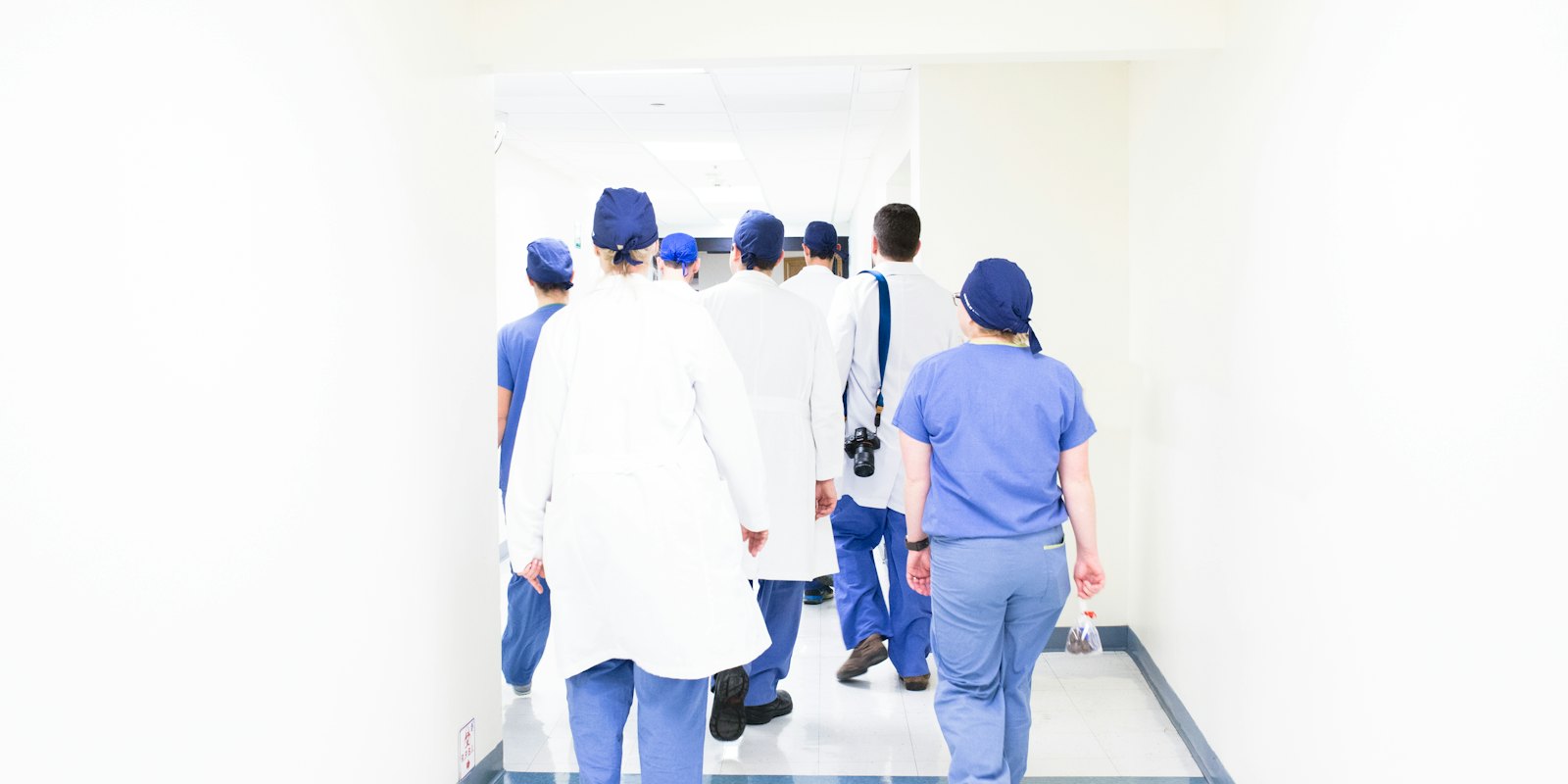 A group of healthcare staff walking down a bright corridor