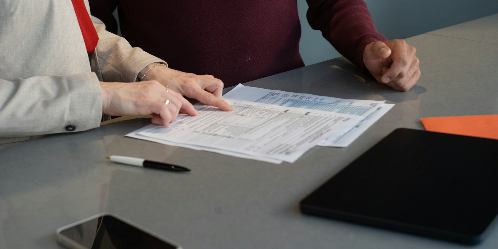 Two people going through documents at a table